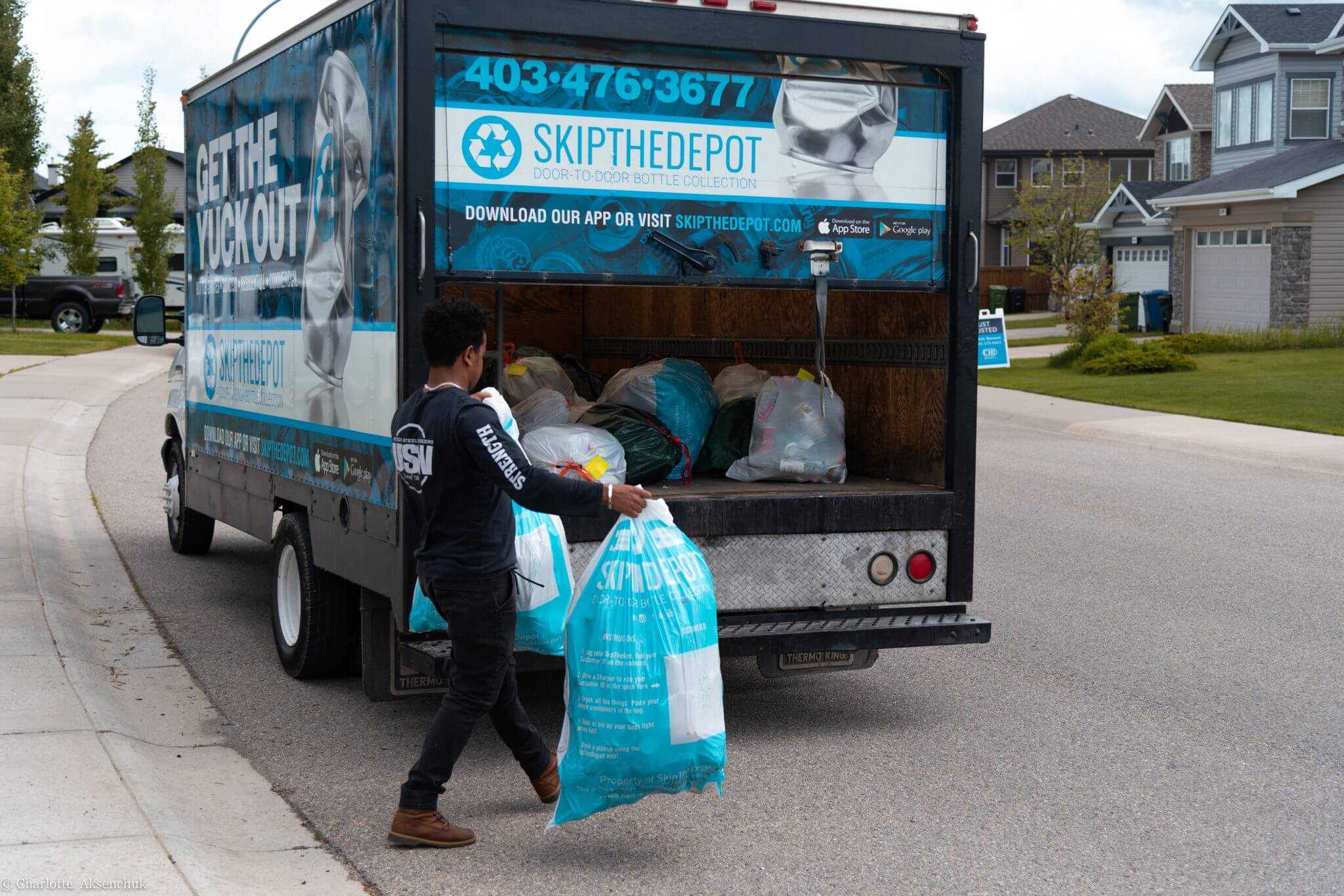 SkipTheDepot driver completing a home bottle pickup and loading his truck up with bags.