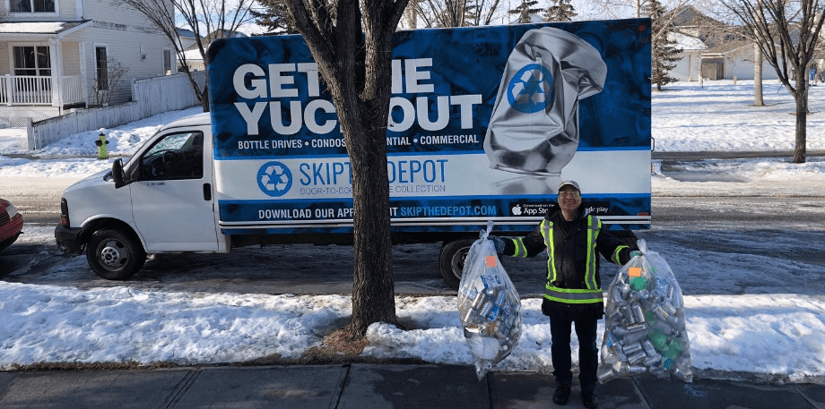 Happy person standing in front of a SkipTheDepot truck, holding a bag of bottle recycling with a big smile.