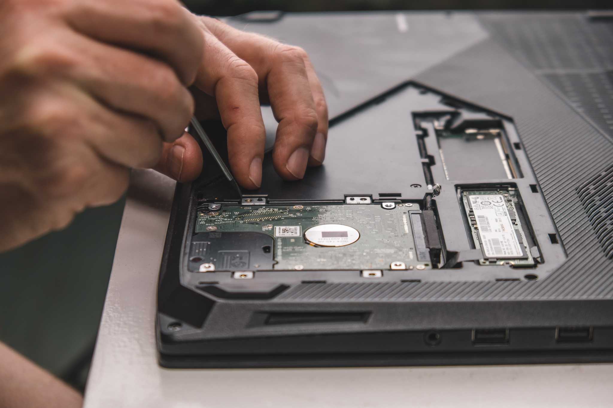 Man removing a hard drive from their laptop.